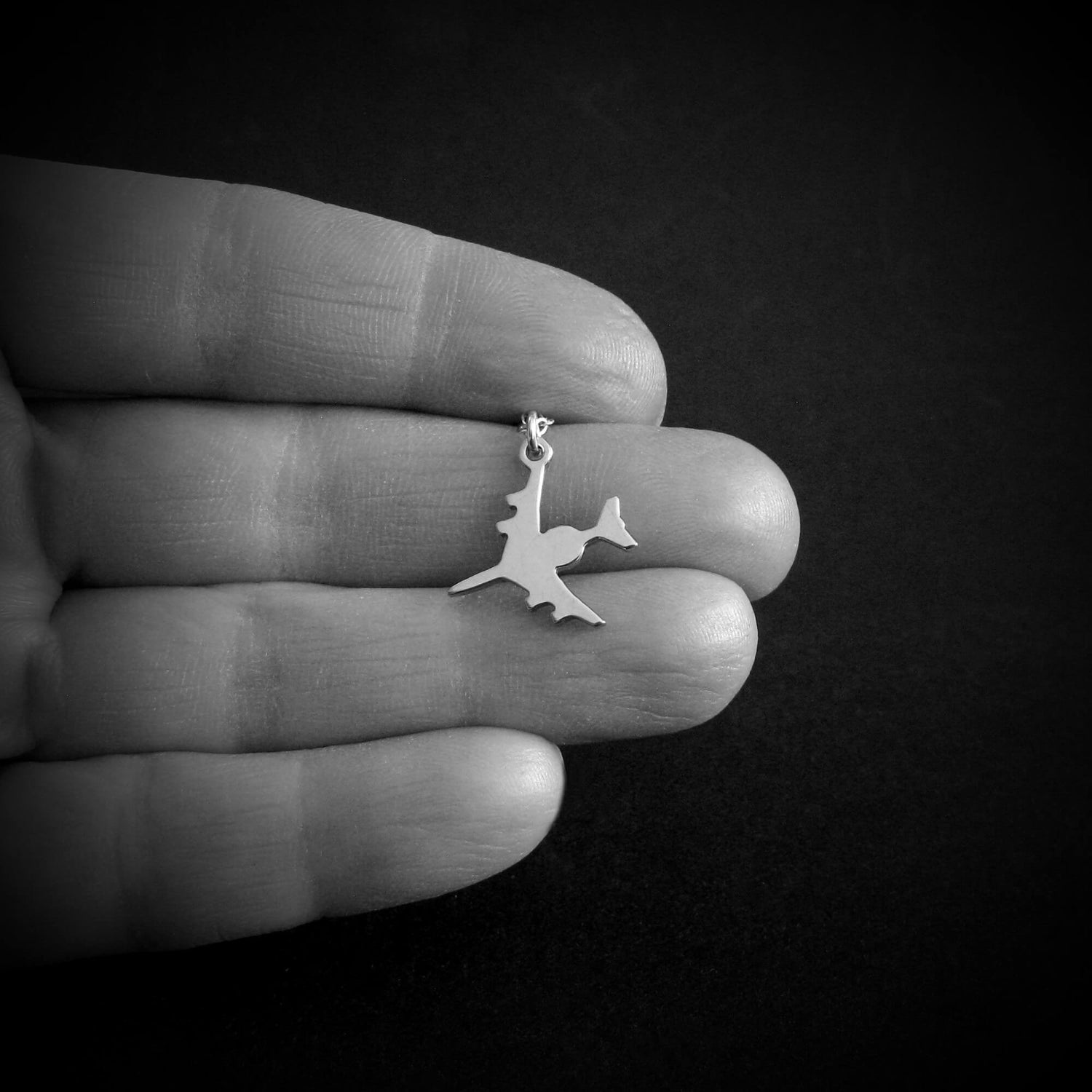 Sterling silver E-3 Sentry AWACS military jet airplane necklace shown in hand for size