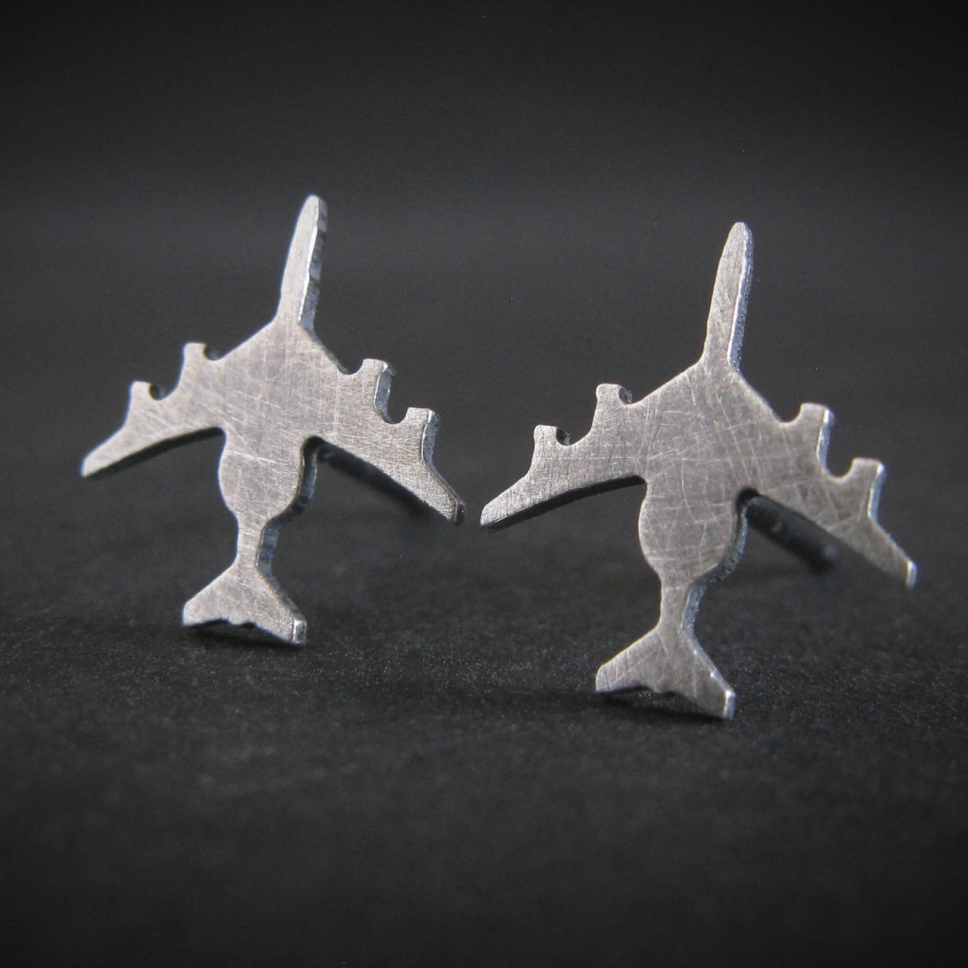 Antiqued Sterling Silver E-3 Sentry military jet airplane shaped stud earrings on a black background