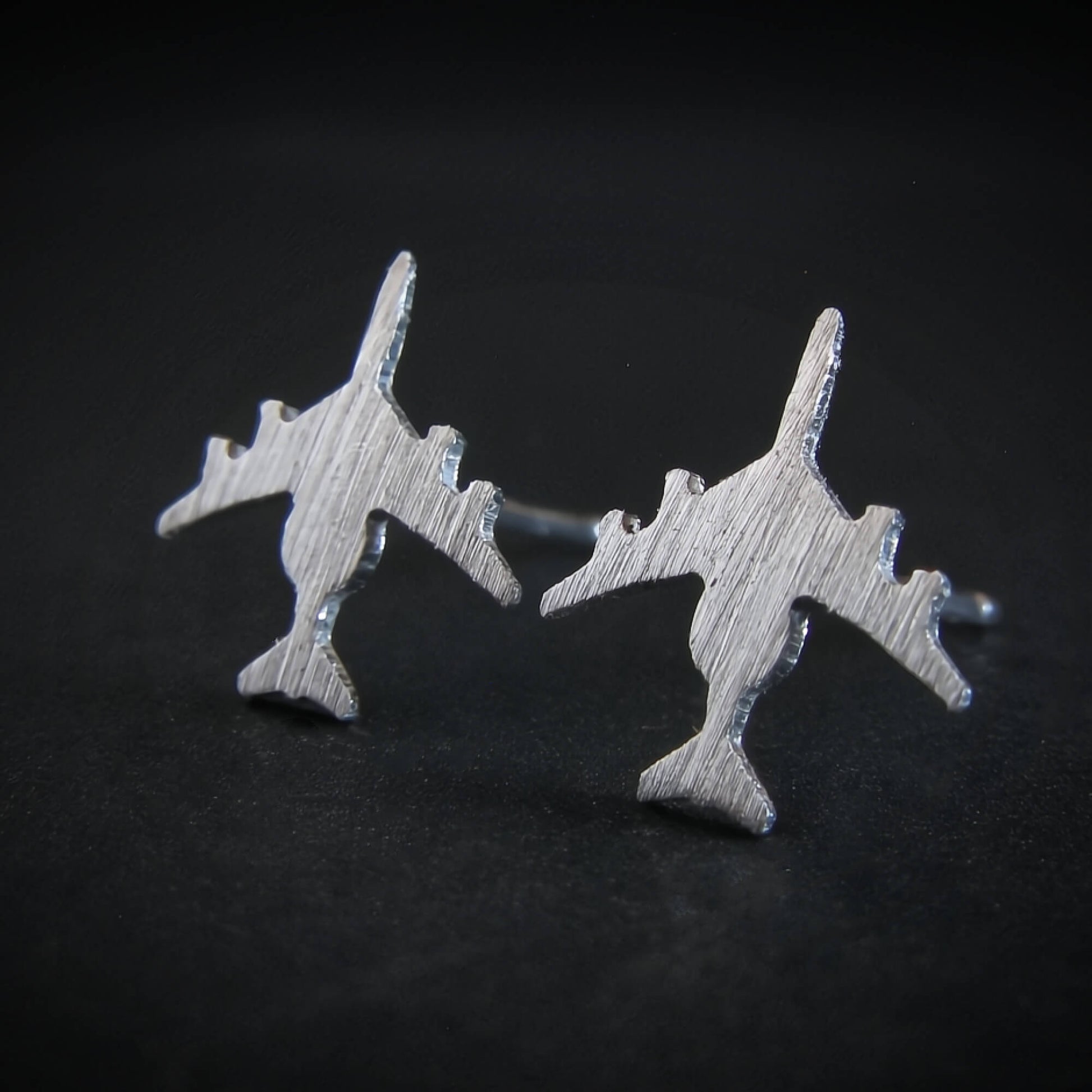 Brushed Silver E-3 Sentry military jet airplane shaped earrings on a black background