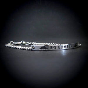 Silver bracelet with 'B-2 Bomber' engraving on a dark background