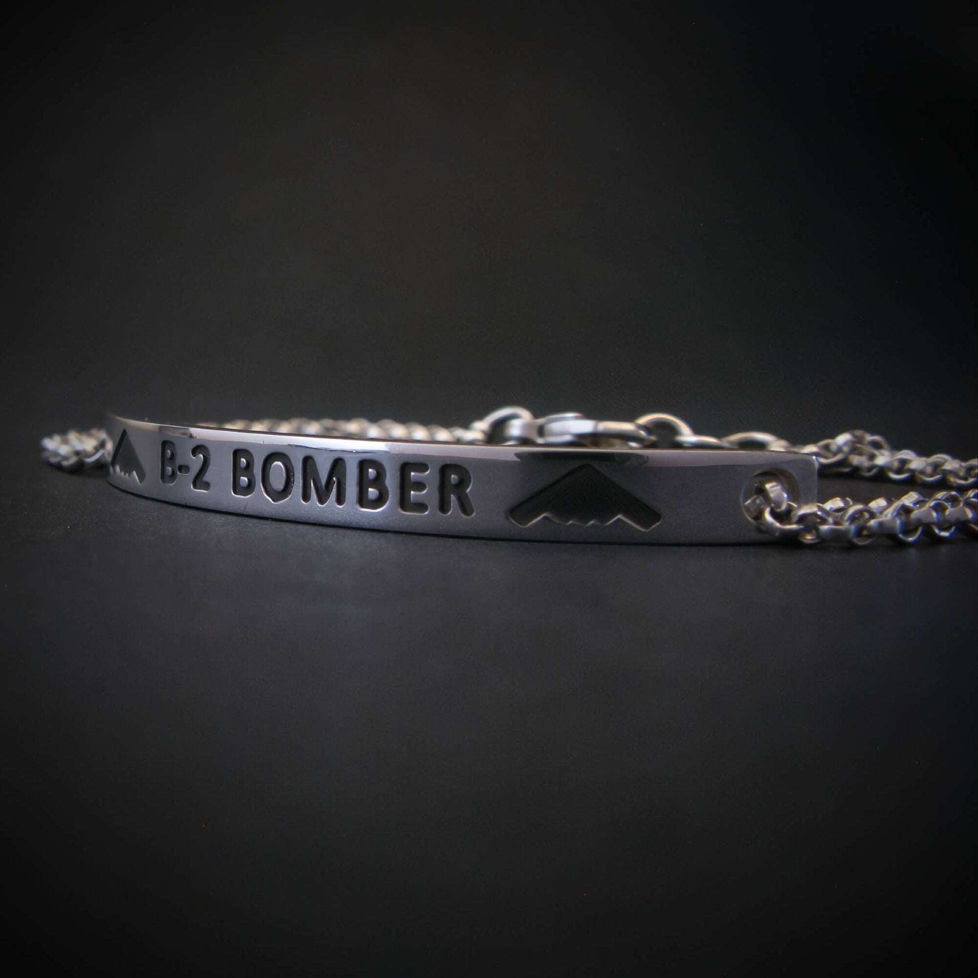 Silver bracelet with 'B-2 Bomber' engraving on a dark background