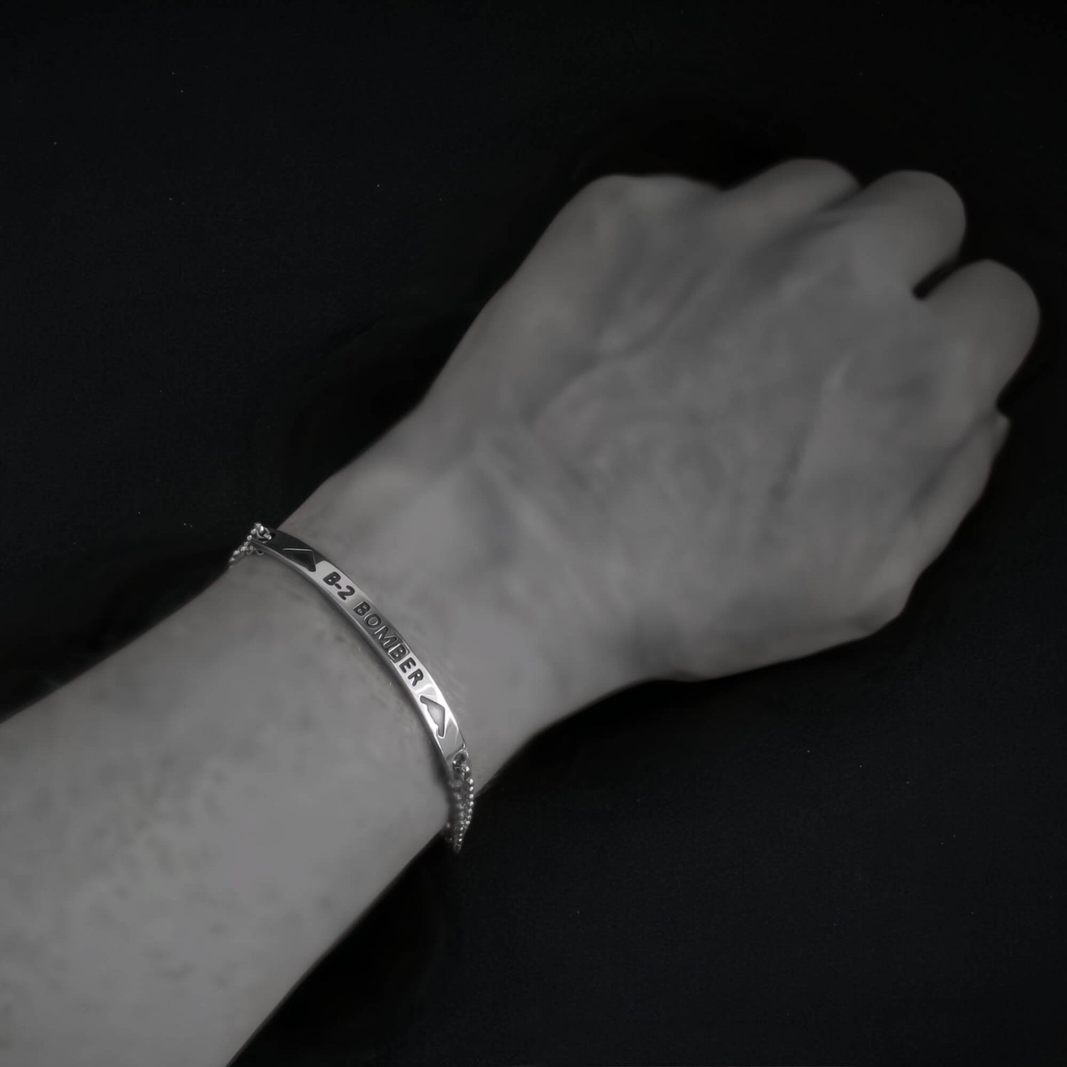 Silver B-2 Bomber Military Jet bracelet on a wrist against a black background