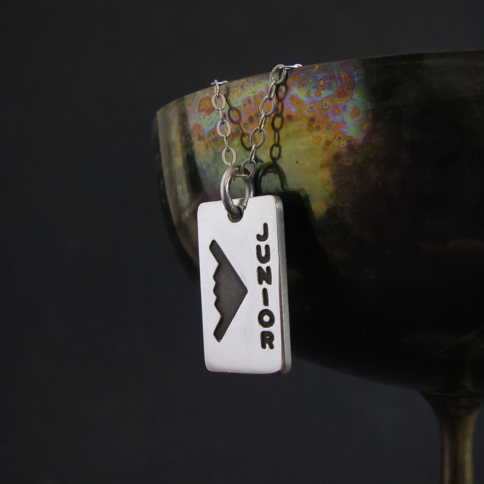 B‑2 Spirit stealth bomber “Junior” engraved pendant necklace displayed on decorative cup – handmade military aviation jewelry