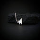 Sterling silver F-117 Nighthawk stealth jet pendant necklace resting on black rock – artisan aviation jewelry handmade in USA