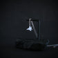 Sterling silver F-15 jet fighter necklace draped on modern black stone display
