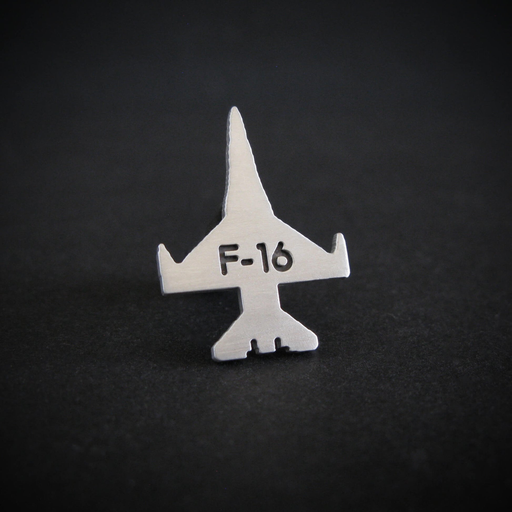 Silver F-16 military jet fighter airplane engraved tie pin on a black background
