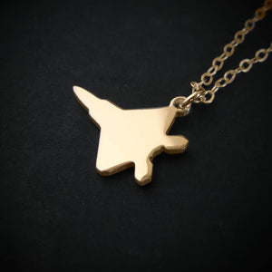 Close-up of the F-22 Raptor pendant necklace in 14k gold on black background