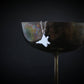 F-22 Raptor pendant in sterling silver hanging on the rim of a bronze cocktail glass