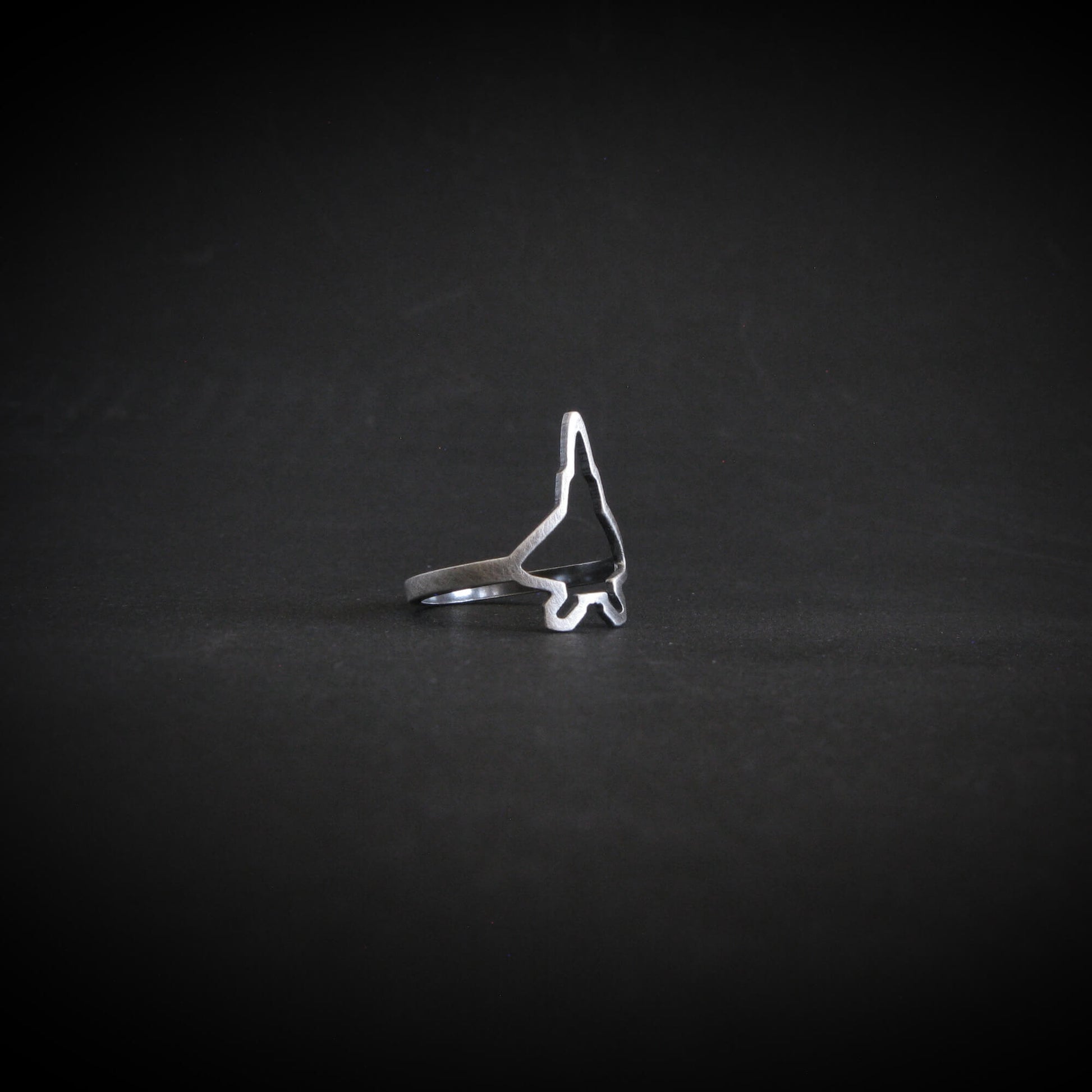 Sterling silver F‑22 Raptor fighter jet silhouette ring – handcrafted aviation jewelry on a dark background

