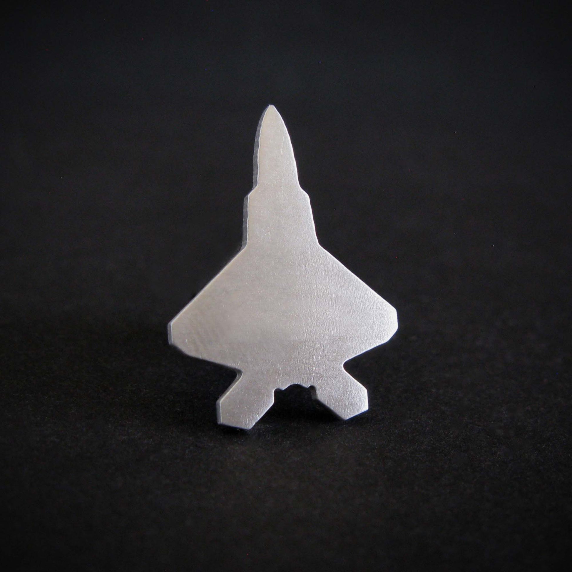 Sterling silver F-22 Raptor fighter jet  tie pin on a black background