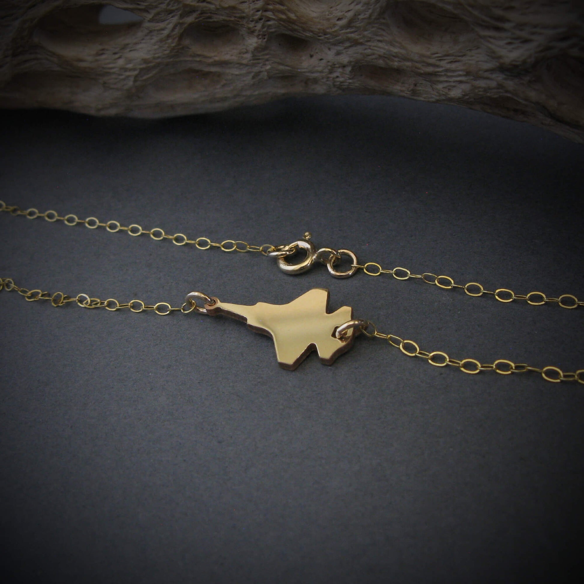 F-35 Military Fighter Jet Inline Necklace in 14k gold against a dark background