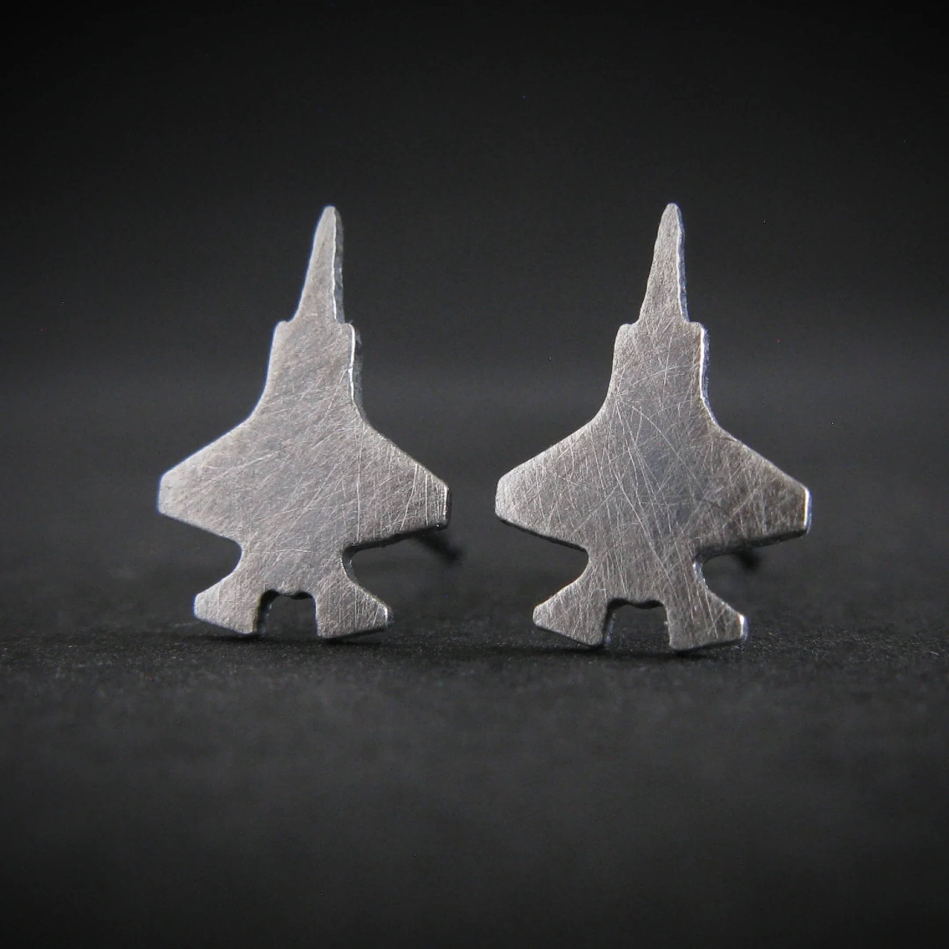 Antiqued F-35 jet shaped stud earrings with a dark background