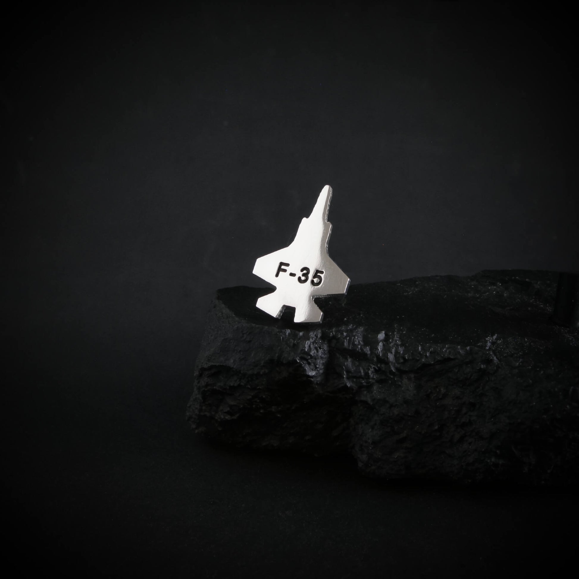 Sterling Silver Tie Pin of an F-35 military fighter jet on a dark background