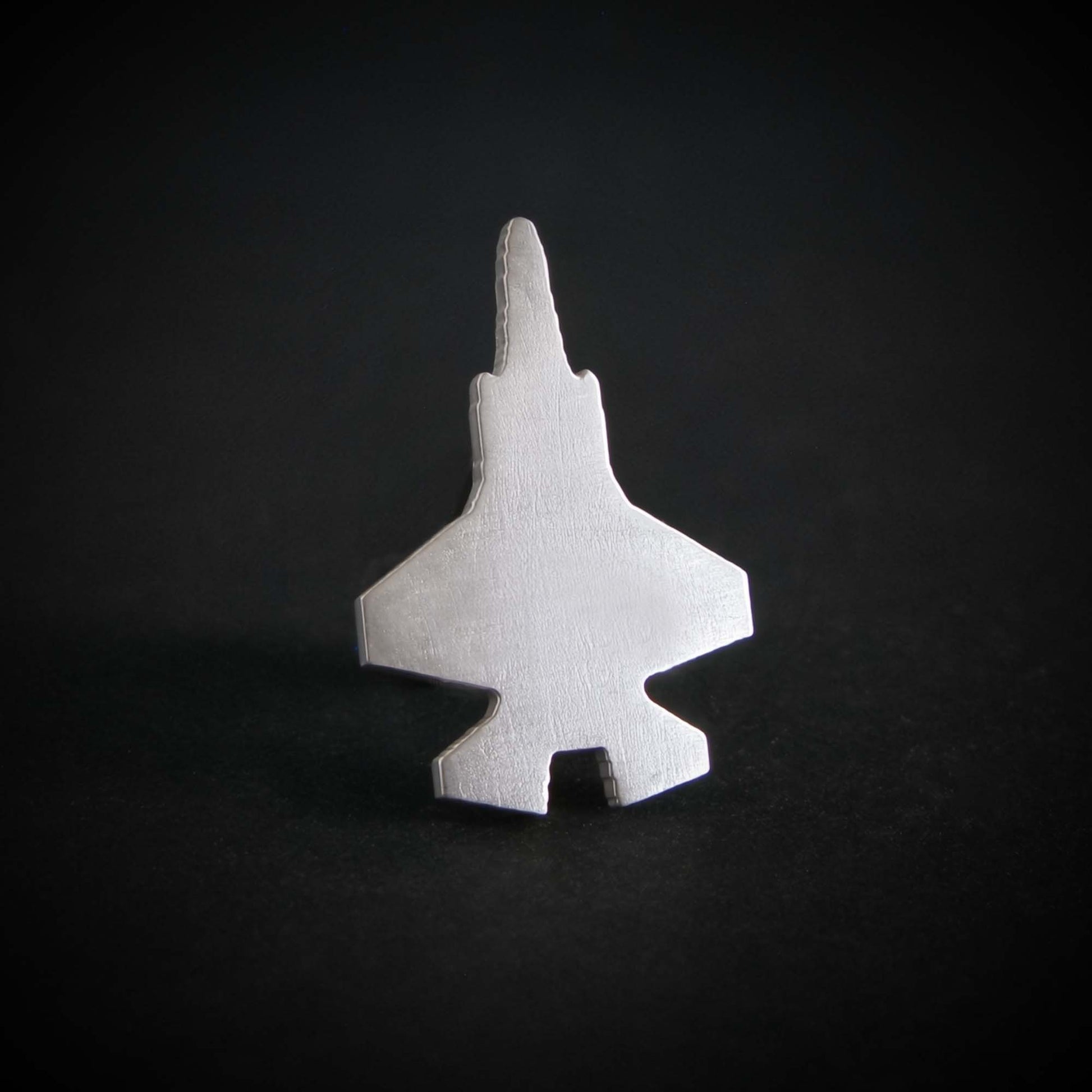 Sterling silver F-35 Lightning II tie pin on a black background
