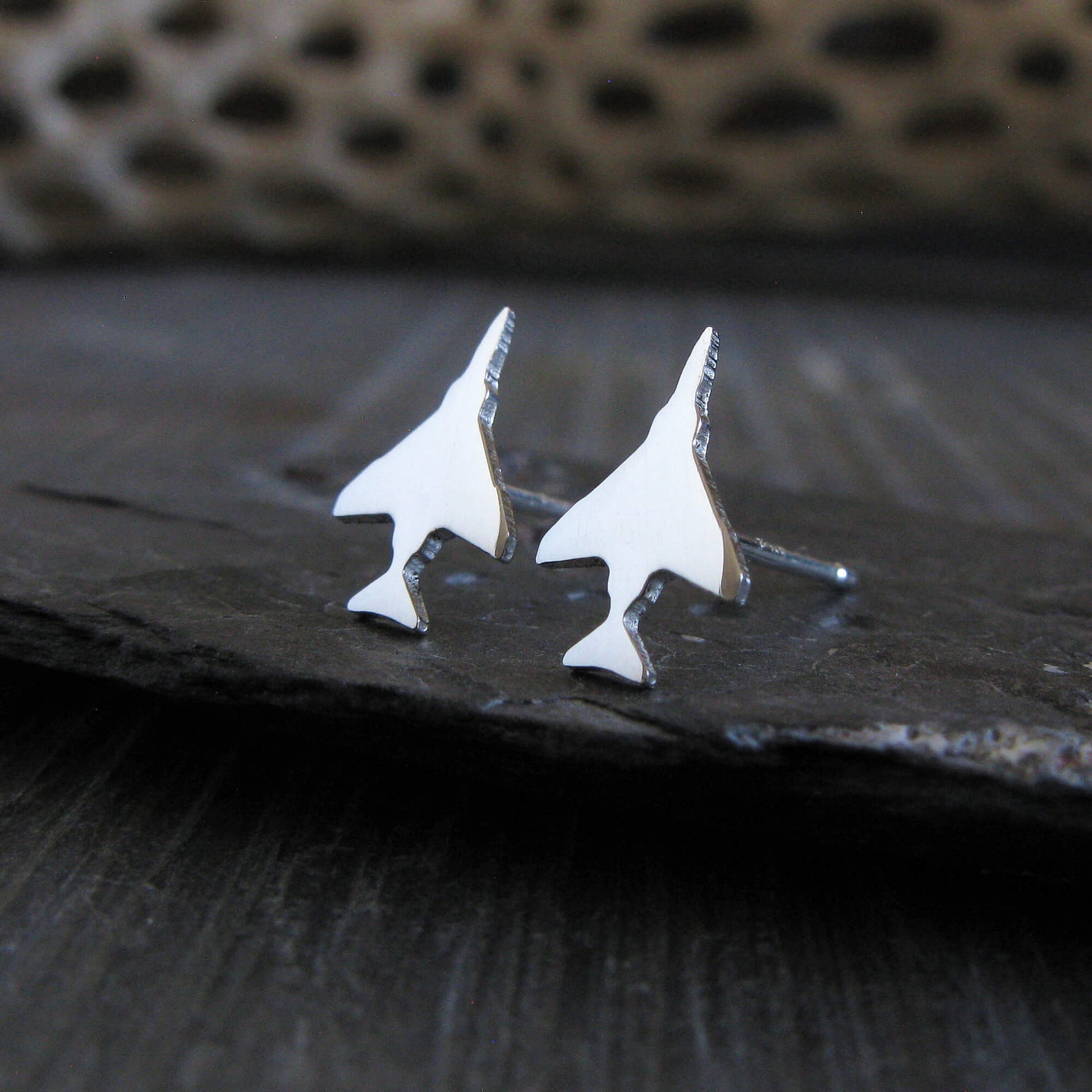Antiqued Sterling Silver F-4 Phantom Military Jet airplane shaped earrings on a stone background