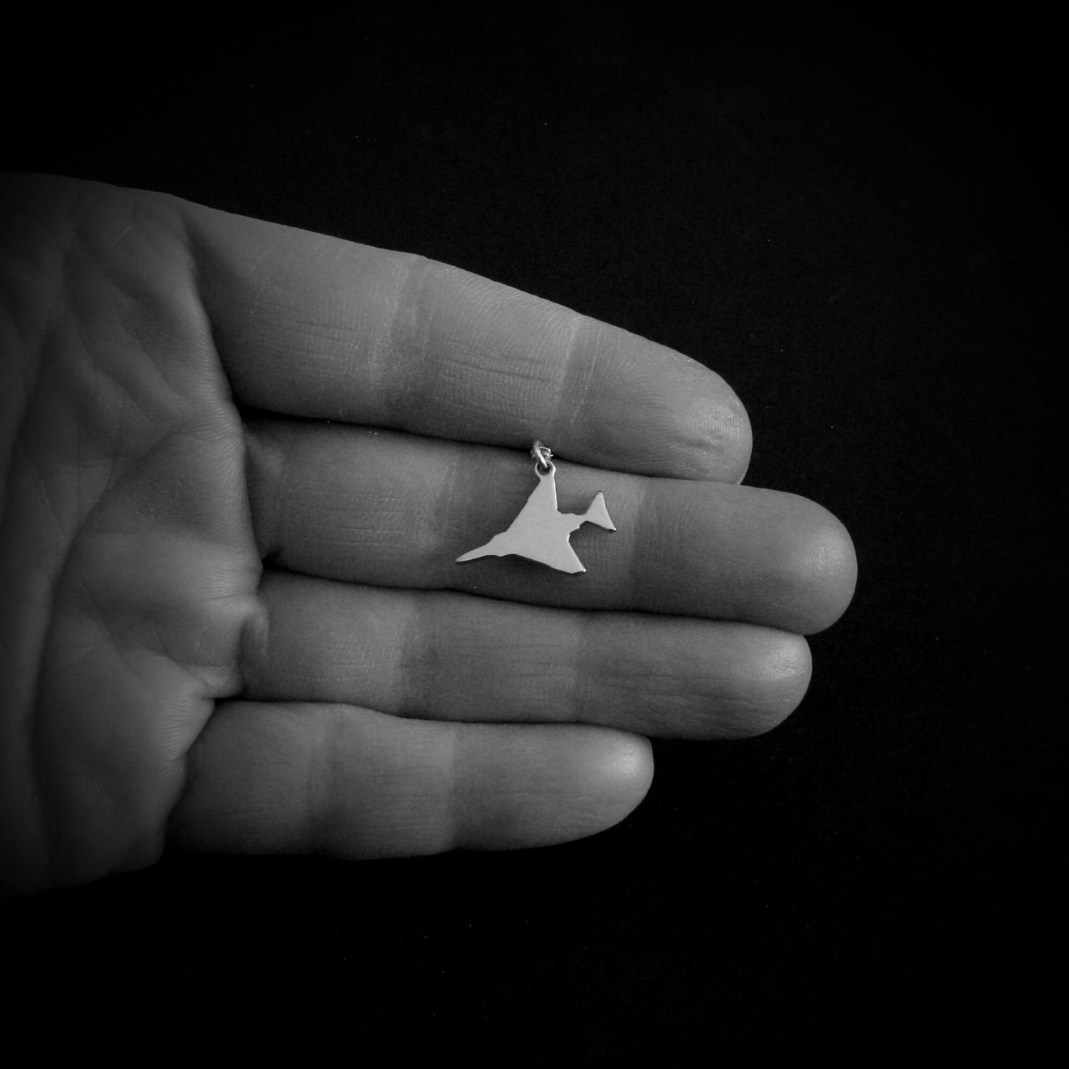 Sterling silver F-4 Phantom military fighter jet pendant necklace shown in hand