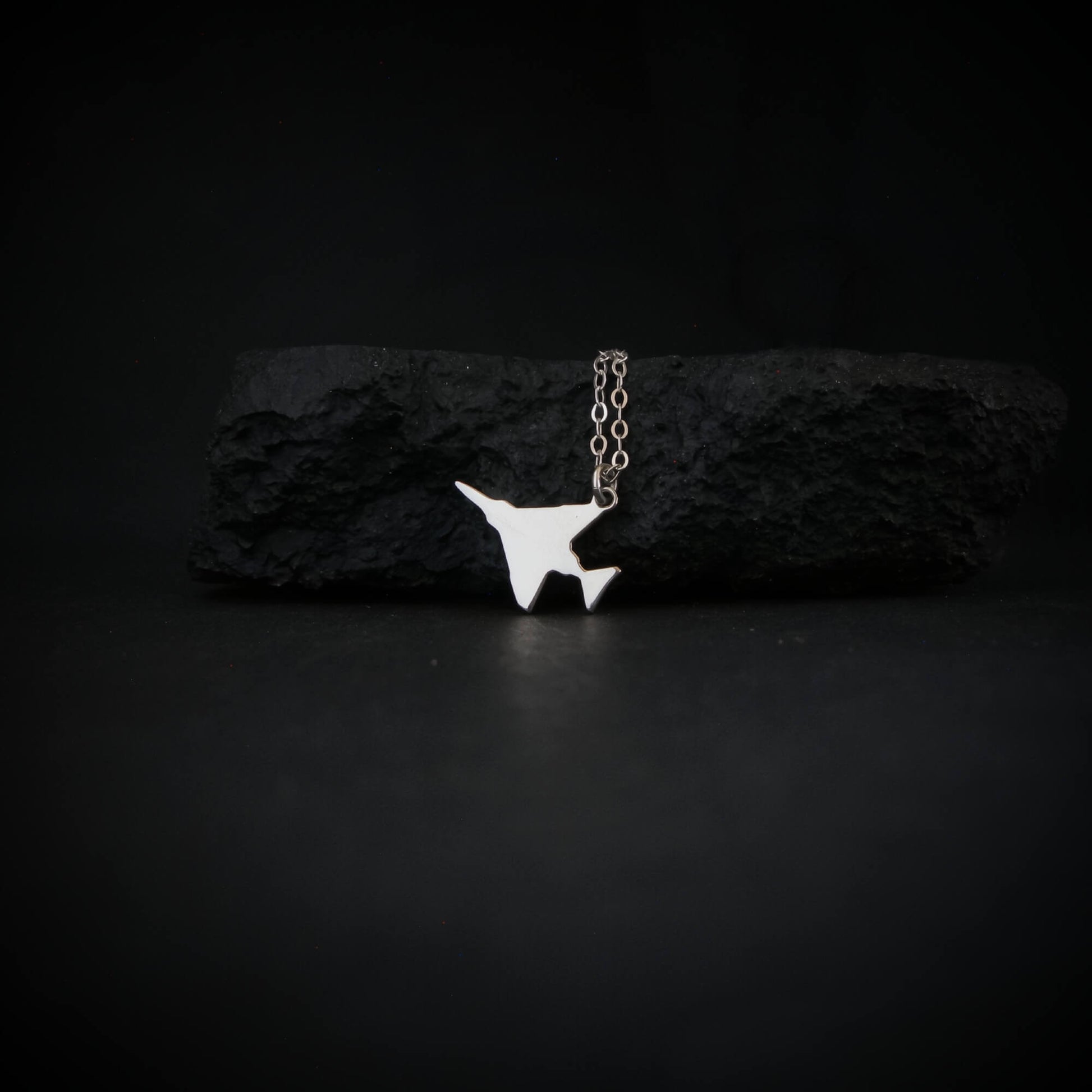 F-4 Phantom military jet airplane pendant necklace in sterling silver displayed on black stone