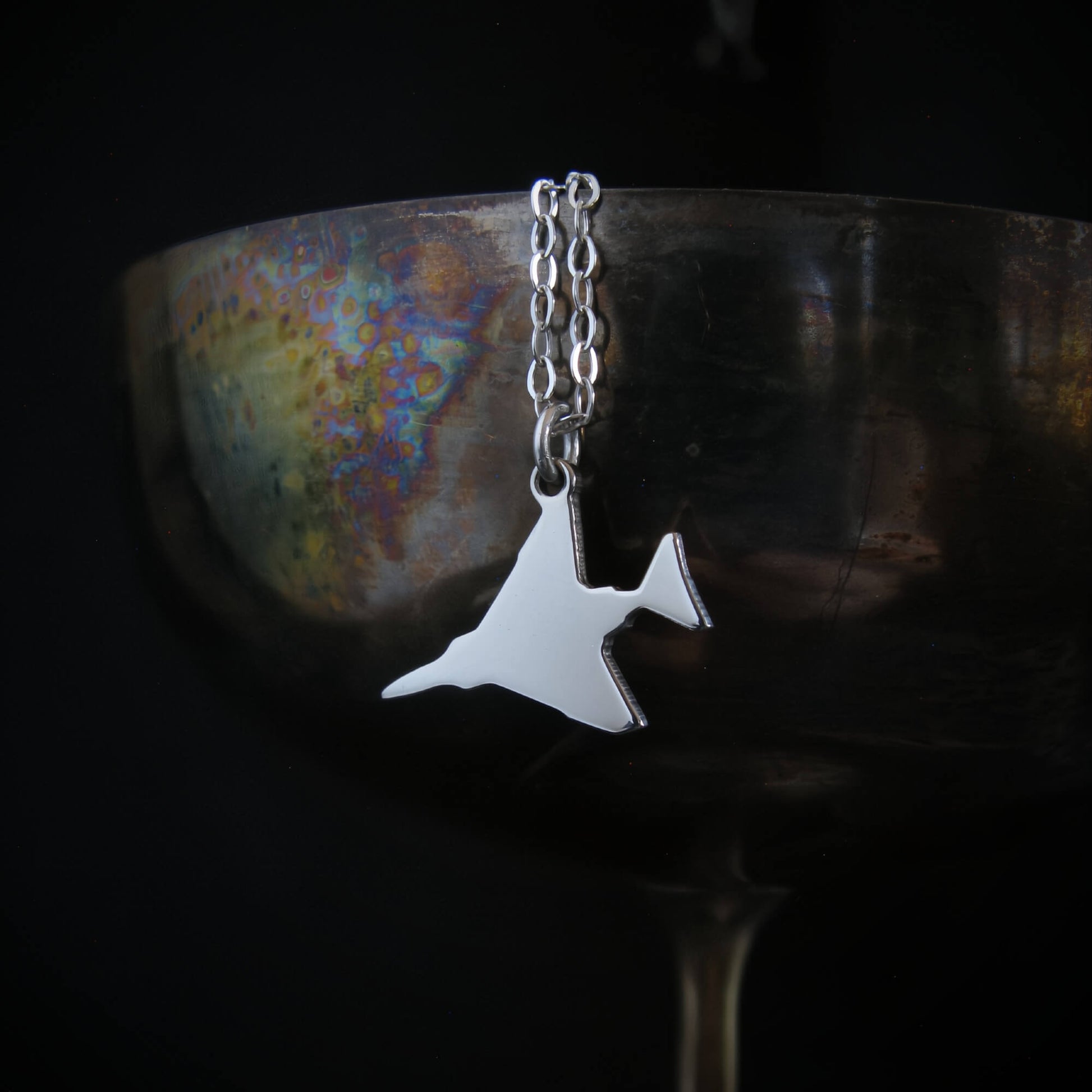 F-4 Phantom military jet airplane pendant necklace in sterling silver on wine goblet.