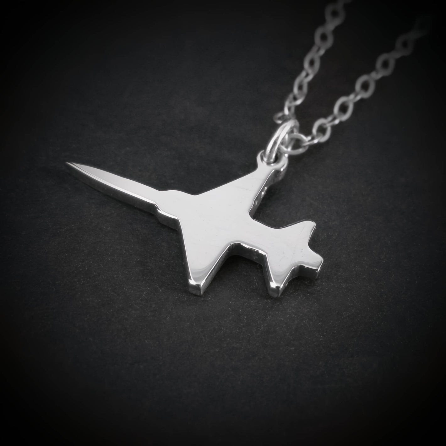 Close-up of sterling silver F-5 Freedom Fighter airplane pendant necklace – handmade aviation and military jewelry