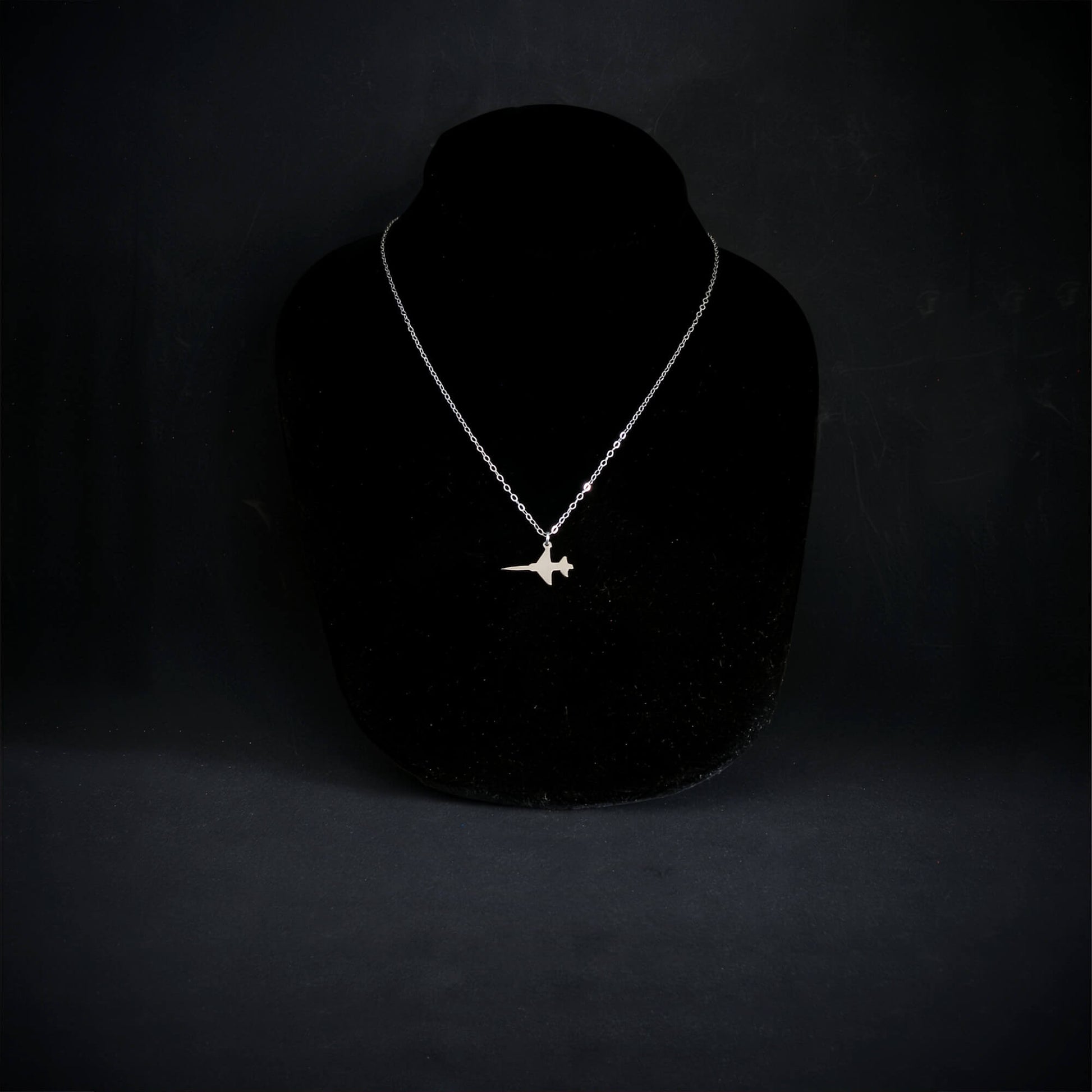 Sterling silver F-5 Freedom Fighter jet pendant necklace displayed on black bust, handmade aviation jewelry