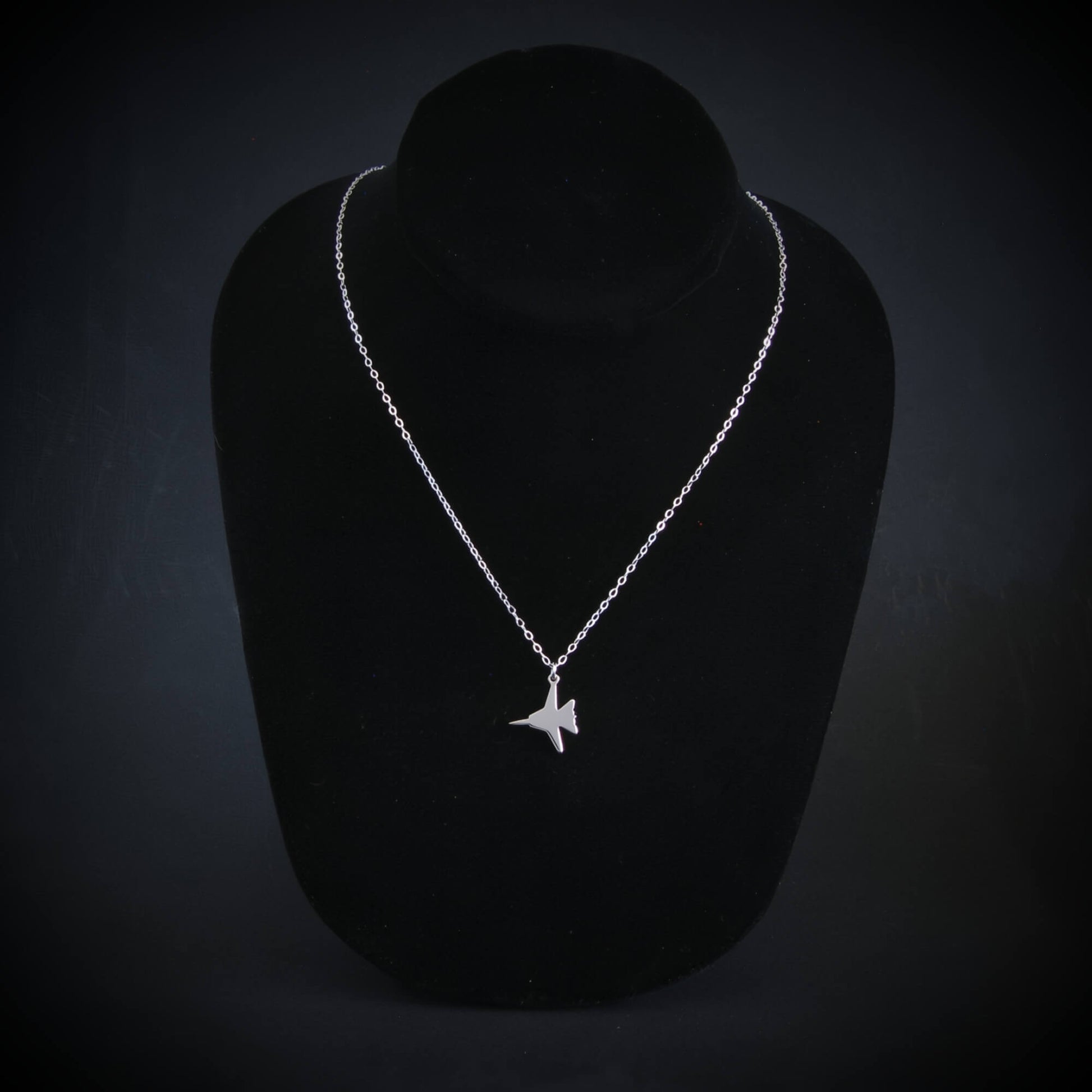 Sterling silver F-14 Tomcat fighter jet pendant necklace on black bust display, handmade Navy aviation jewelry