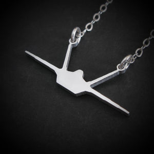 Closeup of sterling silver F-22 Raptor pendant — iconic military jet necklace handmade in the USA