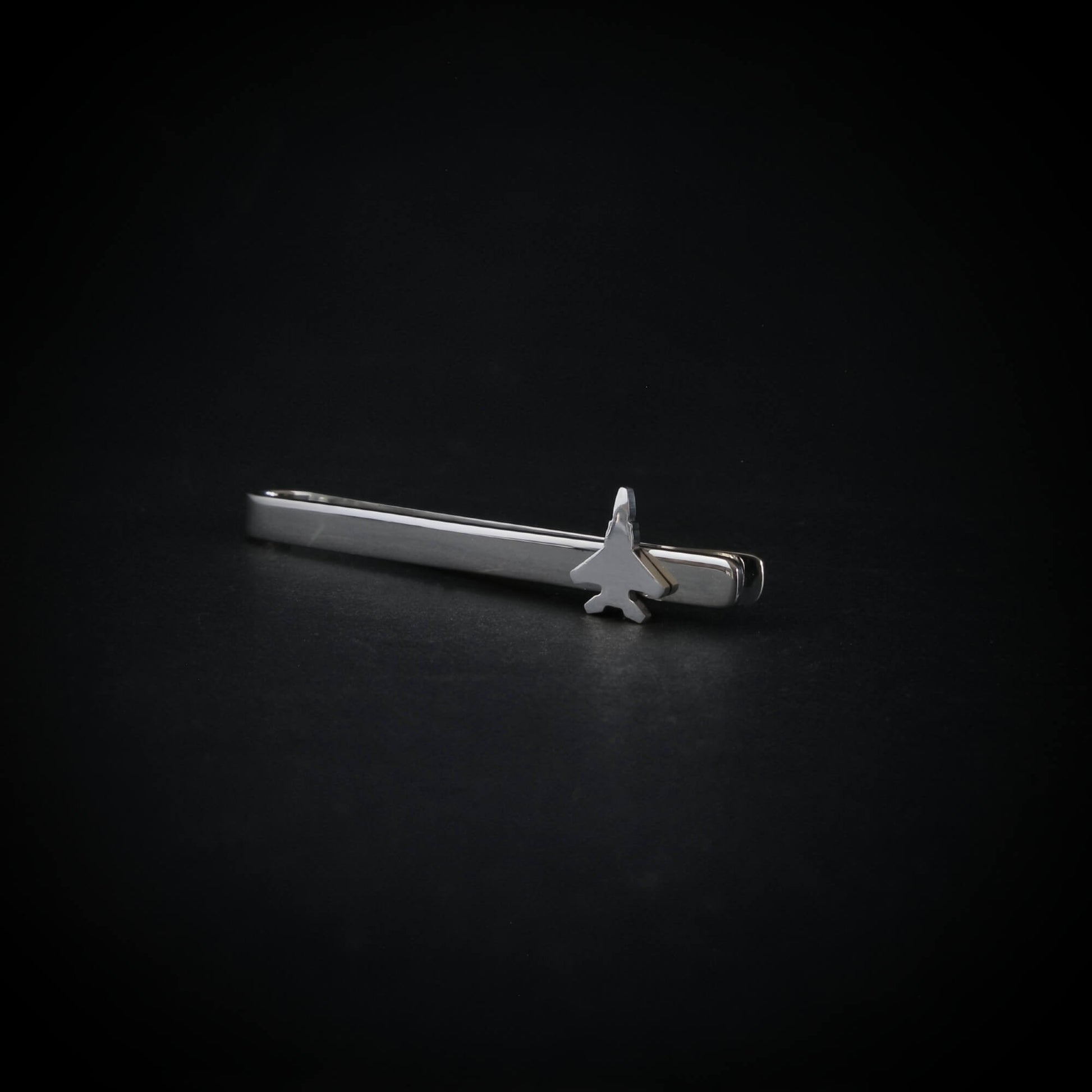 Silver tie clip with an F15 Fighter jet design on a black background