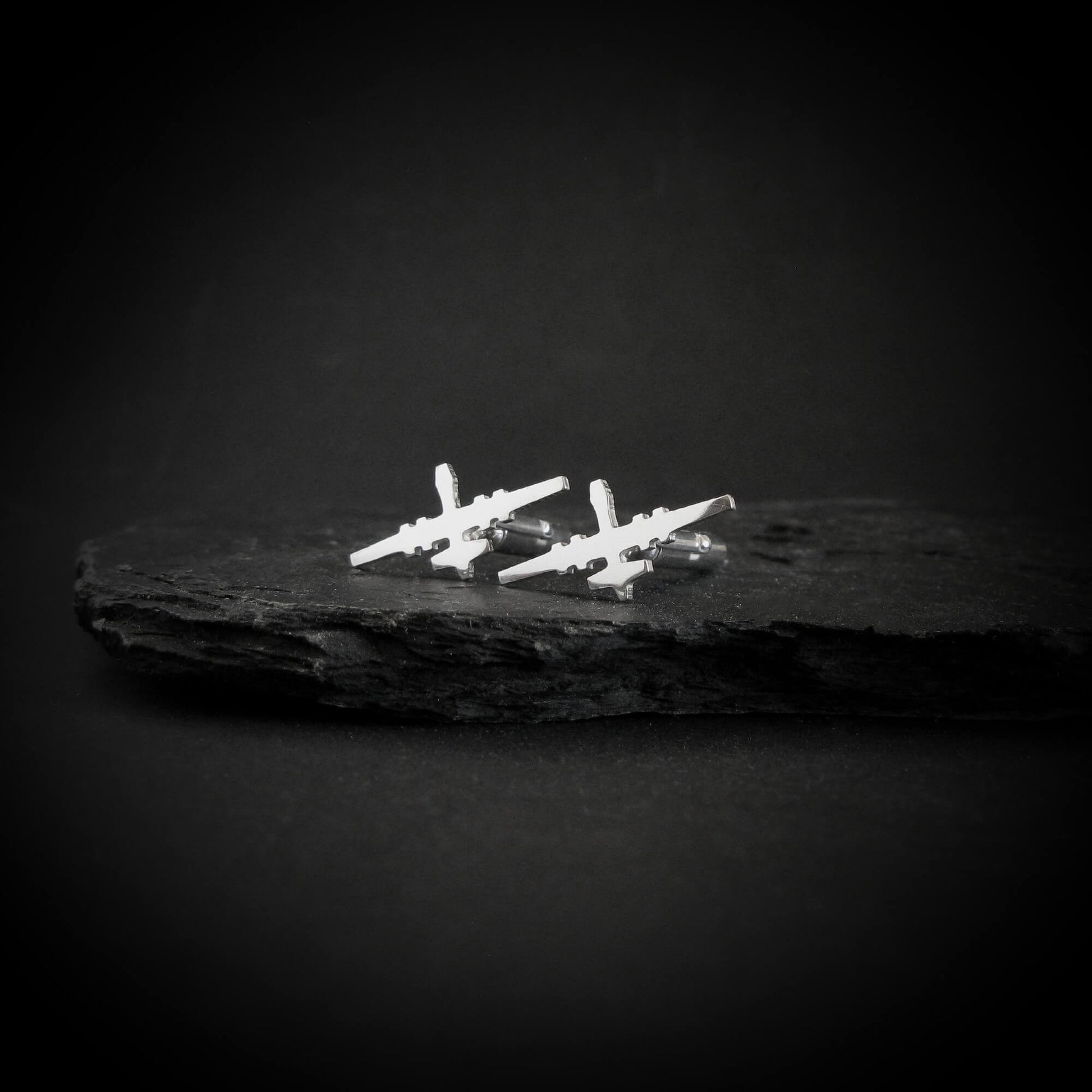 MQ-9 Reaper drone cufflinks in polished sterling silver displayed on black slate rock