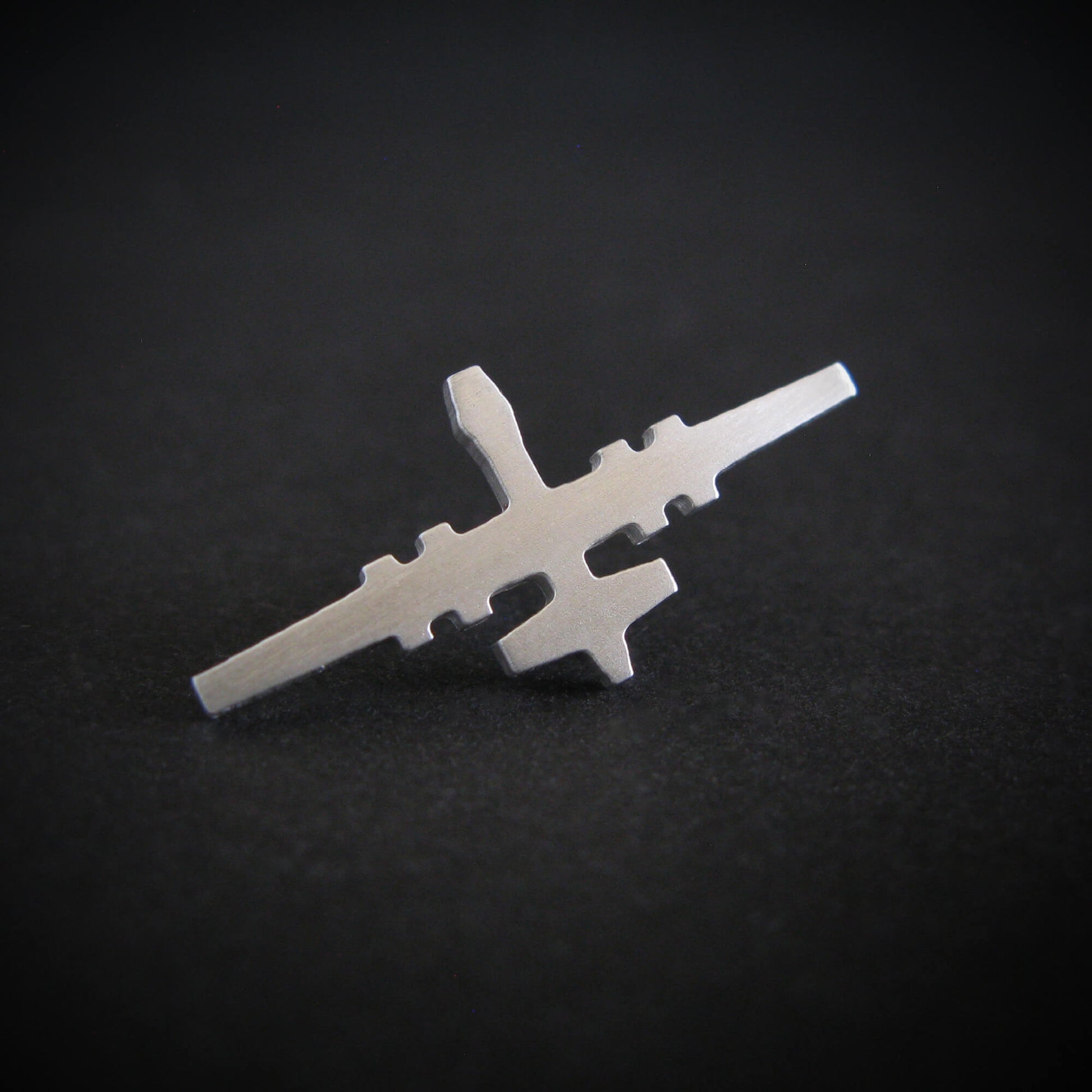 Silver MQ-9 Reaper military drone airplane tie tack on a black background