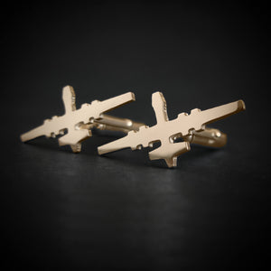 Close-up of MQ-9 Reaper drone cufflinks in polished 14k gold on dark background