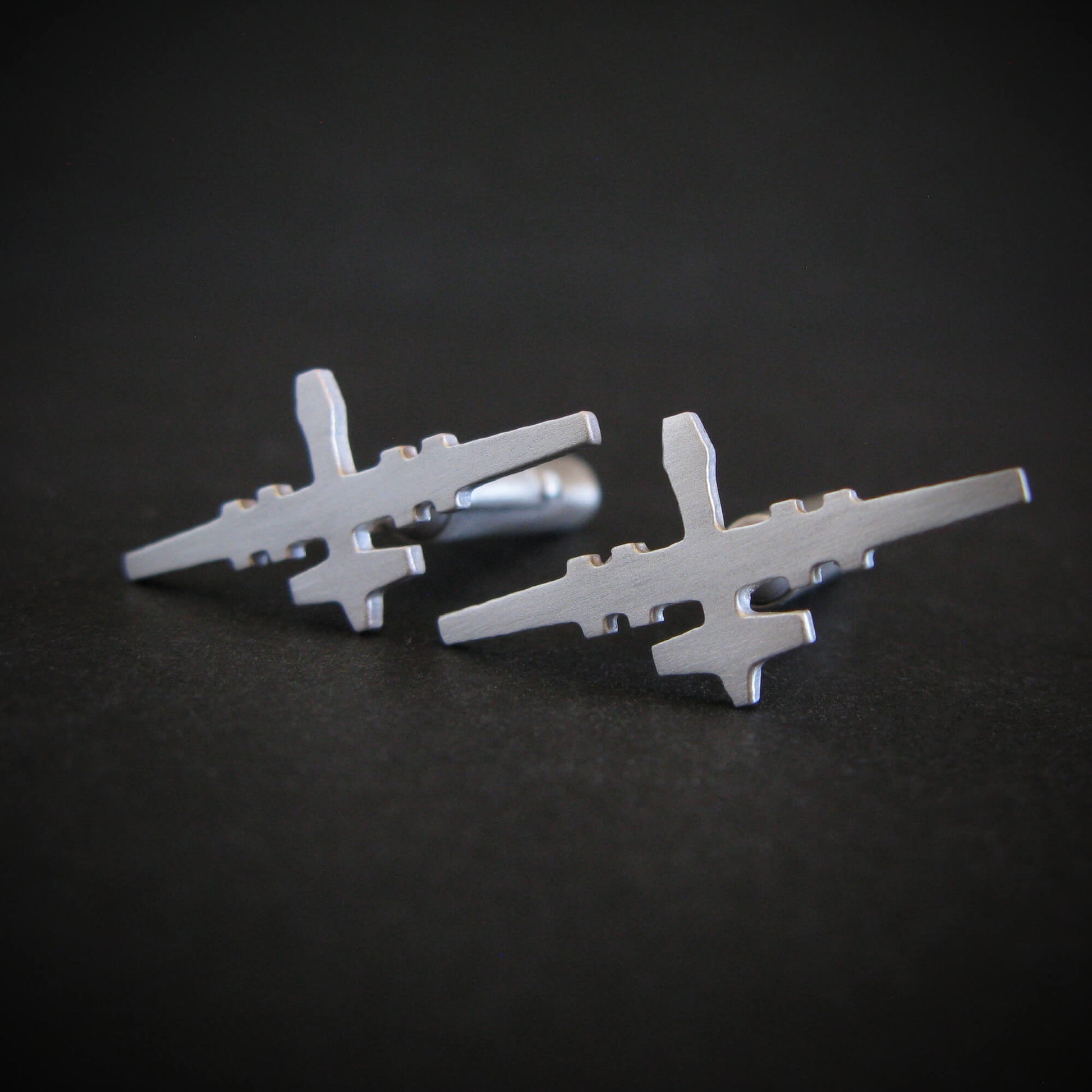 Pair of satin sterling silver MQ-9 Reaper cufflinks displayed on a matte black background