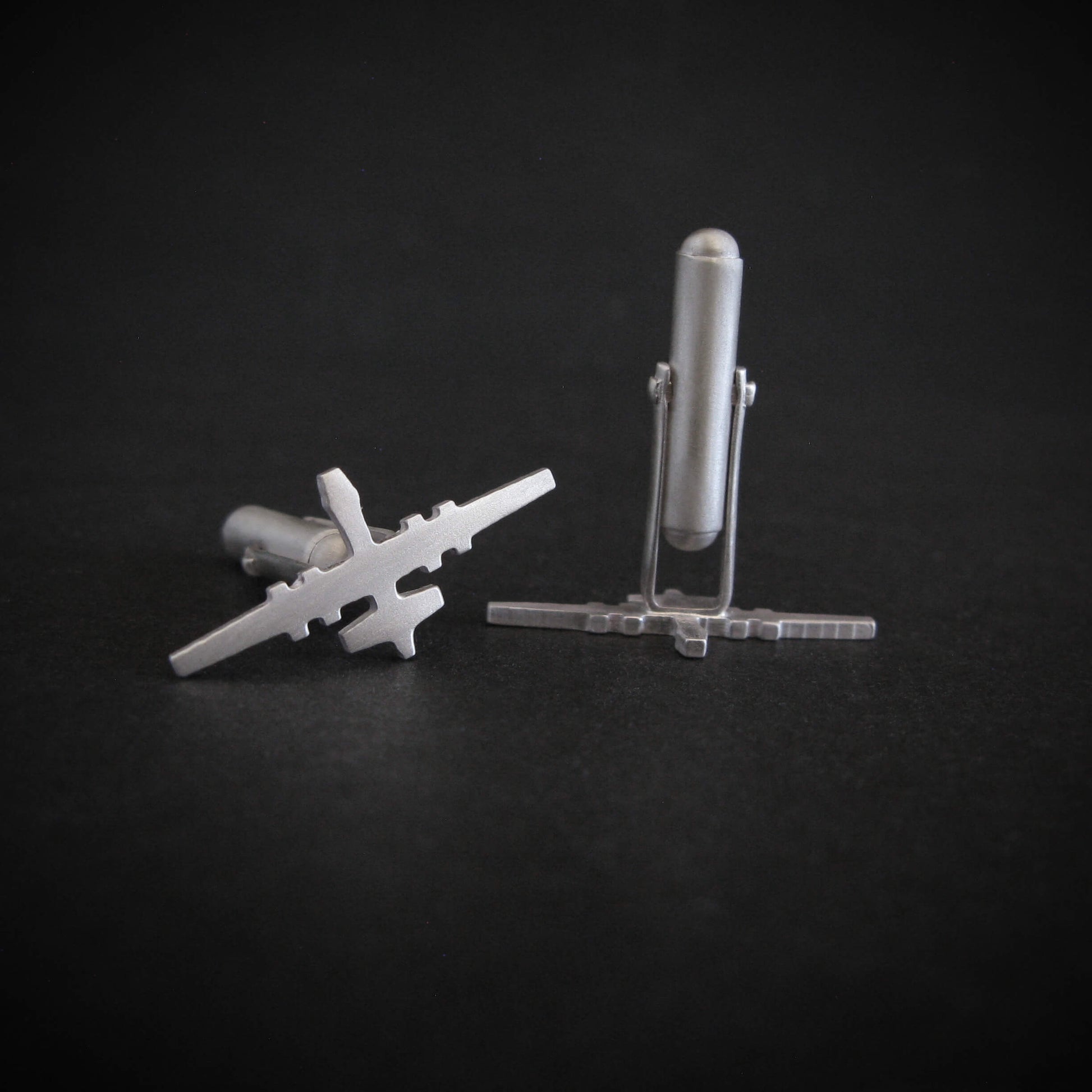 Satin sterling silver MQ-9 Reaper drone cufflinks shown from rear and side angles on black surface