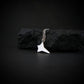 Sterling silver NASA Space Shuttle pendant necklace resting on black rock – artisan space jewelry handmade in USA
