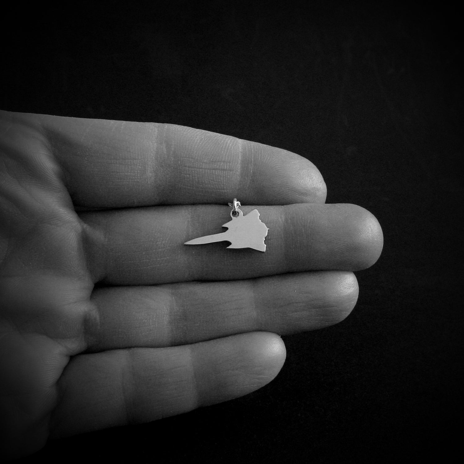 Small SR-71 Blackbird airplane sterling silver pendant necklace shown in hand, military aircraft jewelry