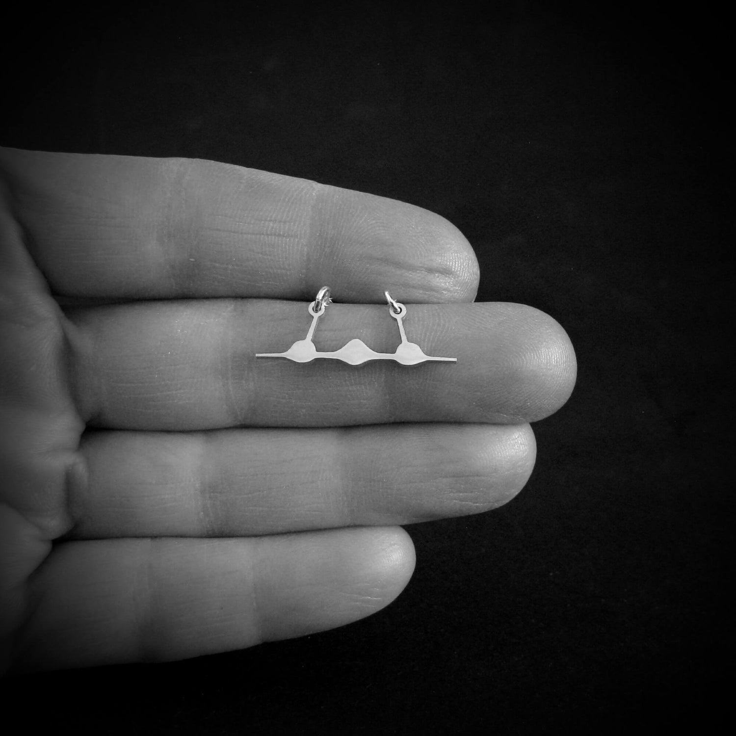 Sterling silver SR-71 Blackbird front-view jet necklace shown in hand for size reference