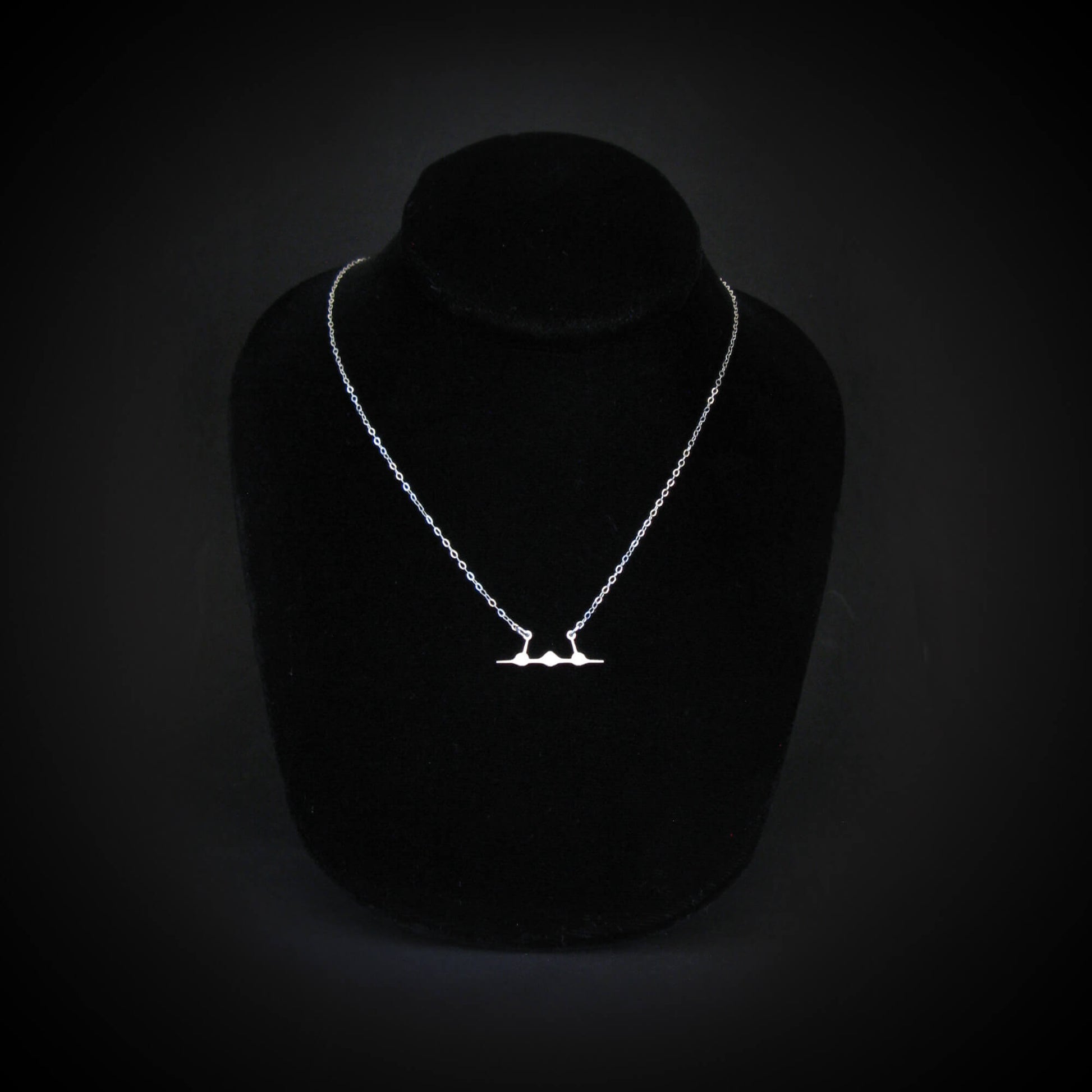SR-71 Blackbird jet silhouette necklace in sterling silver displayed on black jewelry bust