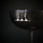 Handmade sterling silver SR-71 Blackbird pendant hanging from rim of vintage metal goblet