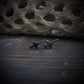 Oxidized sterling silver T-38 Talon military trainer jet stud earrings handcrafted aviation jewelry on stone background