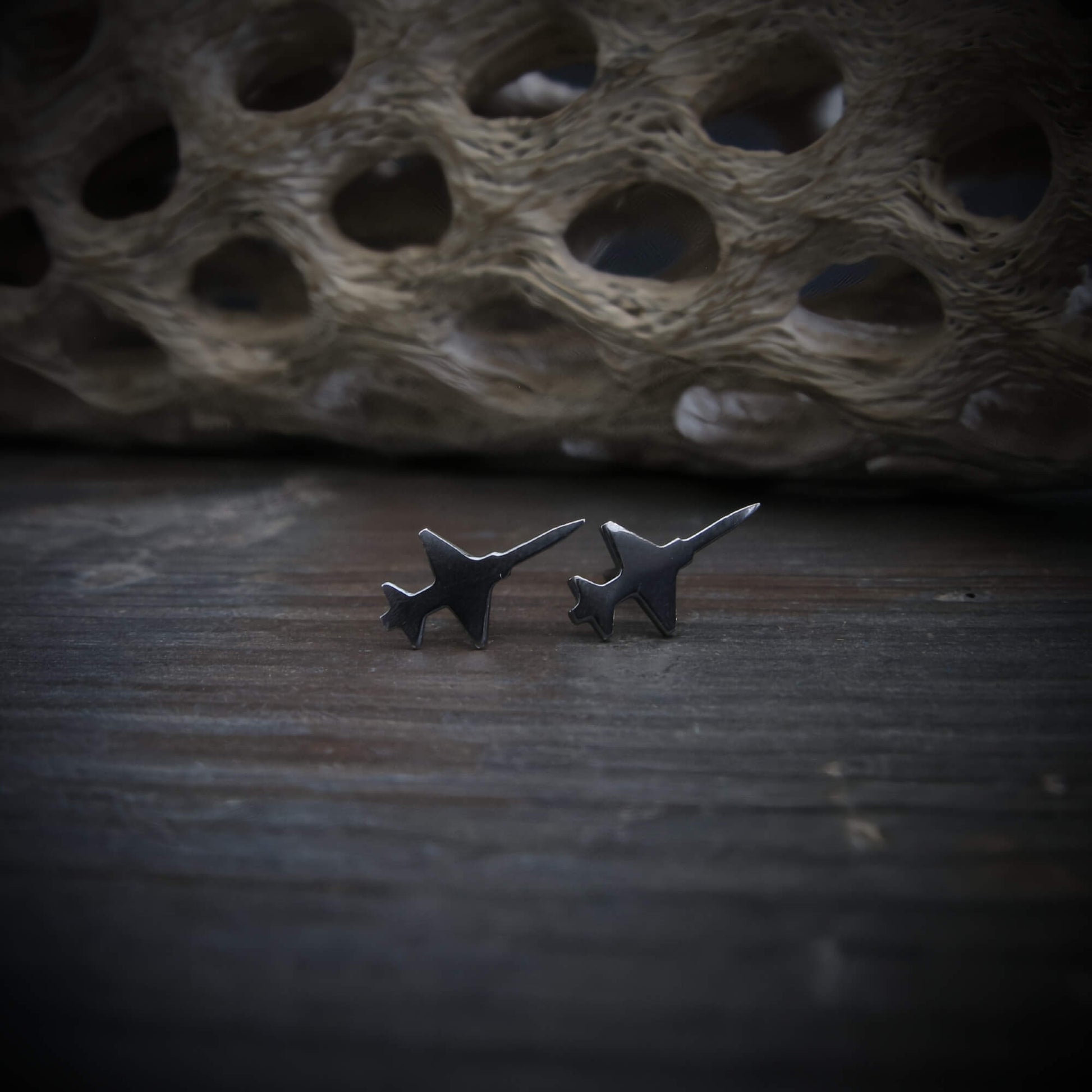 Oxidized sterling silver T-38 Talon military trainer jet stud earrings handcrafted aviation jewelry on stone background