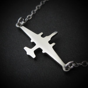 U-2 Dragon Lady military jet pendant necklace in polished sterling silver, displayed close-up against a dark background.