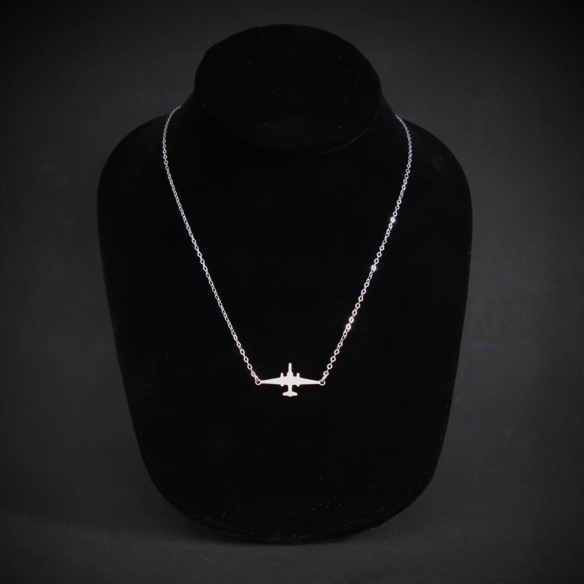 U-2 Dragon Lady military jet pendant necklace in sterling silver, displayed on a black jewelry bust against a dark background.