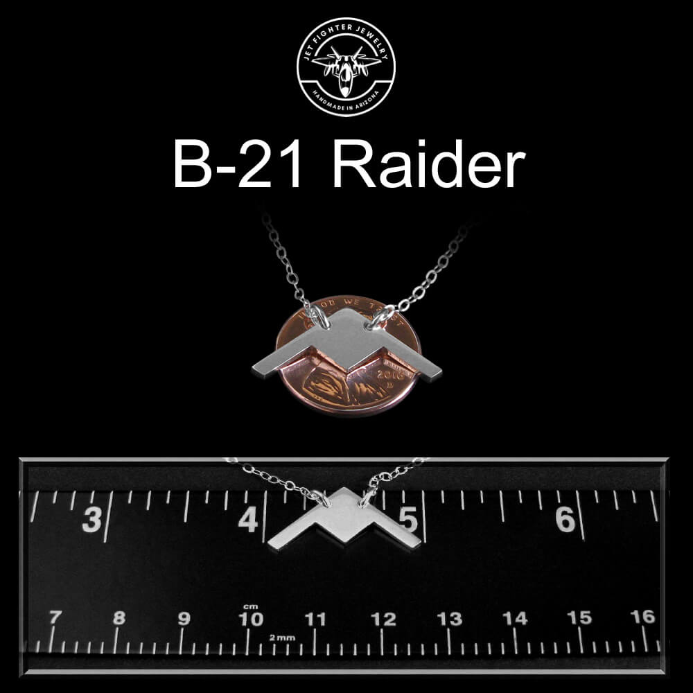 B-21 Raider necklace on a black background with a ruler for scale.