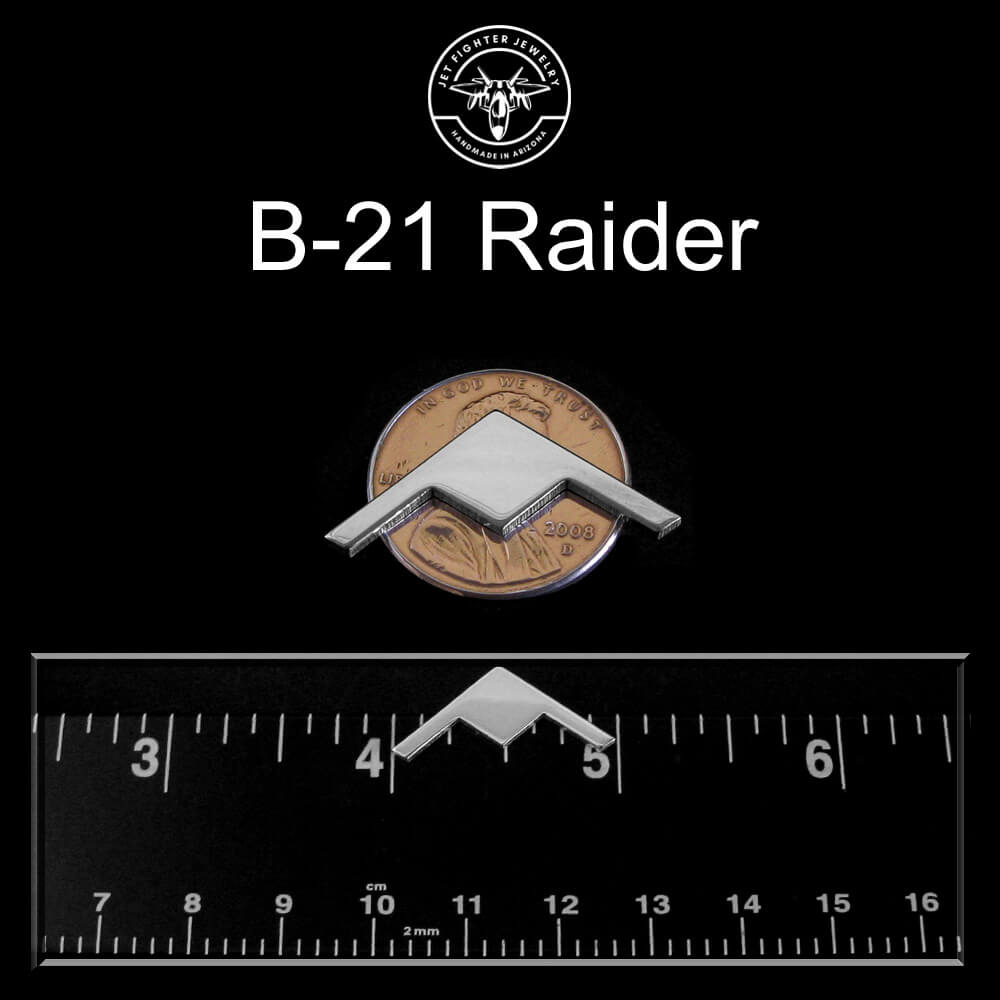 Silver B-21 Raider Tie Pin on a black background with a ruler for scale.