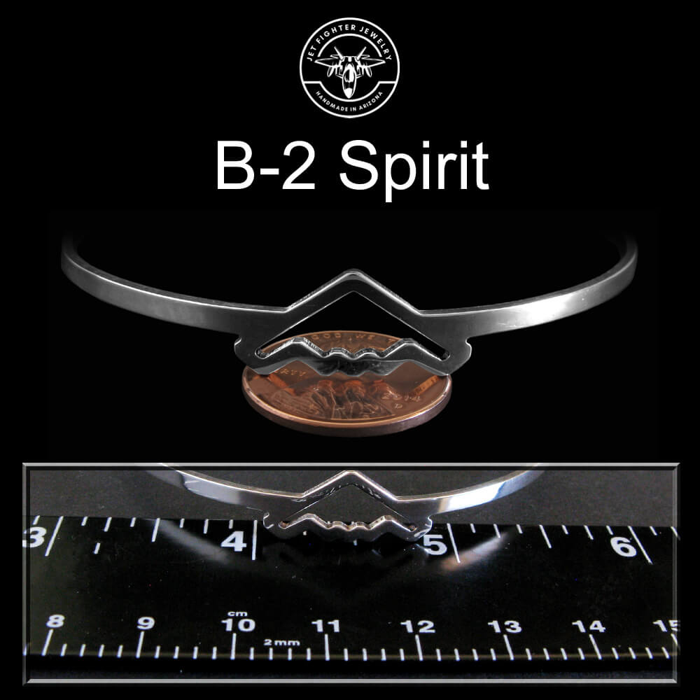 Silver bangle bracelet on penny on a black background, featuring a 'B-2 Spirit'.