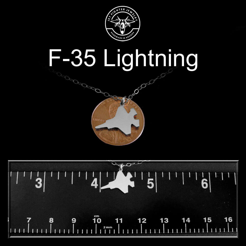 F-35 Lightning necklace with a ruler for scale on a black background