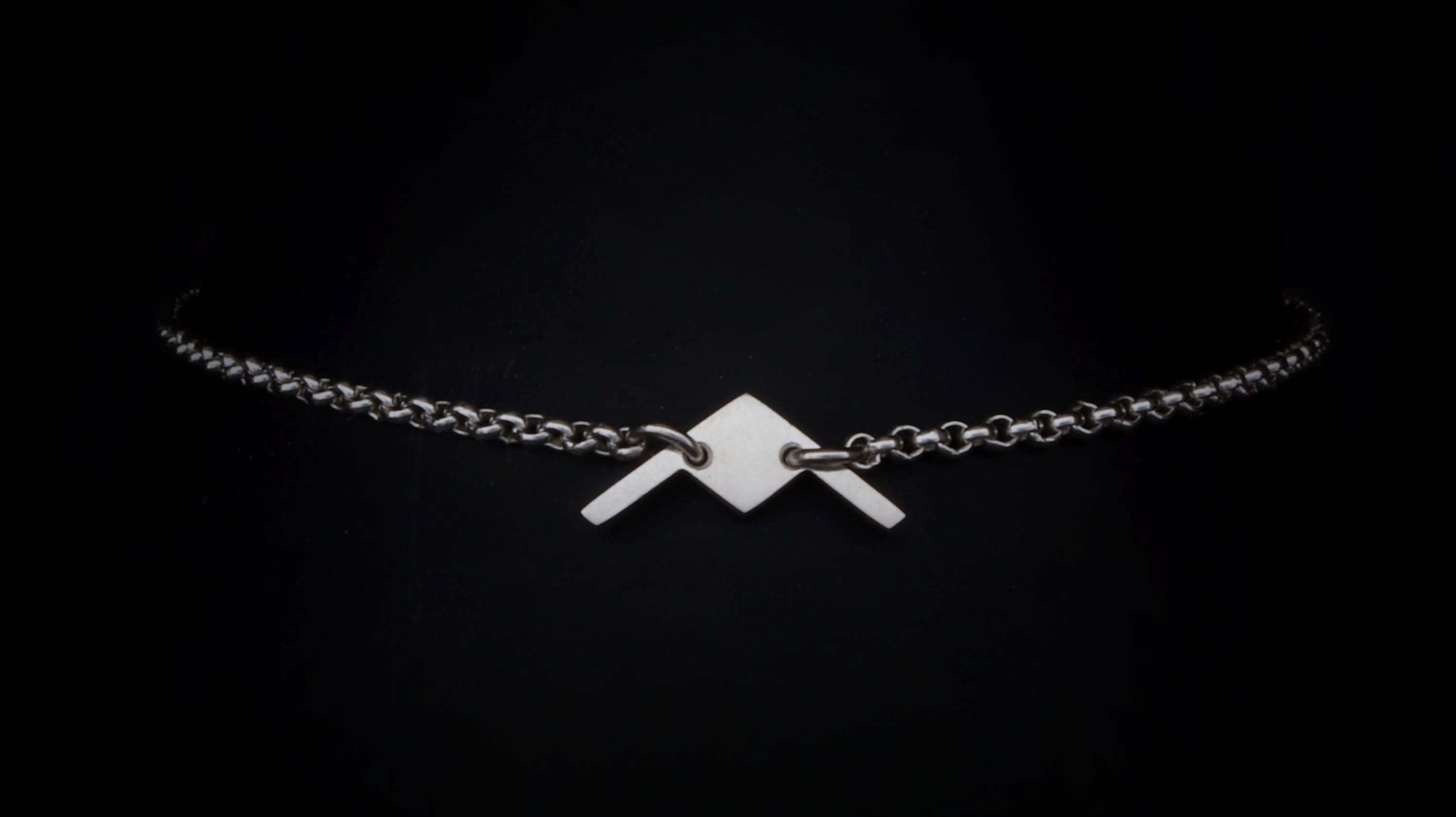 Load video: Close up video of an engraved B-2 Bomber Chain charm bracelet on a turntable
