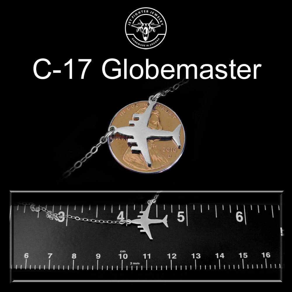 C-17 Globemaster necklace with a coin and airplane pendant on a black background, shown with a ruler for scale.