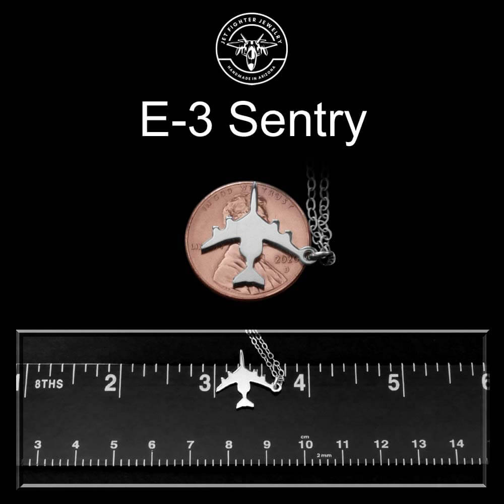E-3 Sentry sterling silver pendant on a penny with black background and on a ruler for scale.