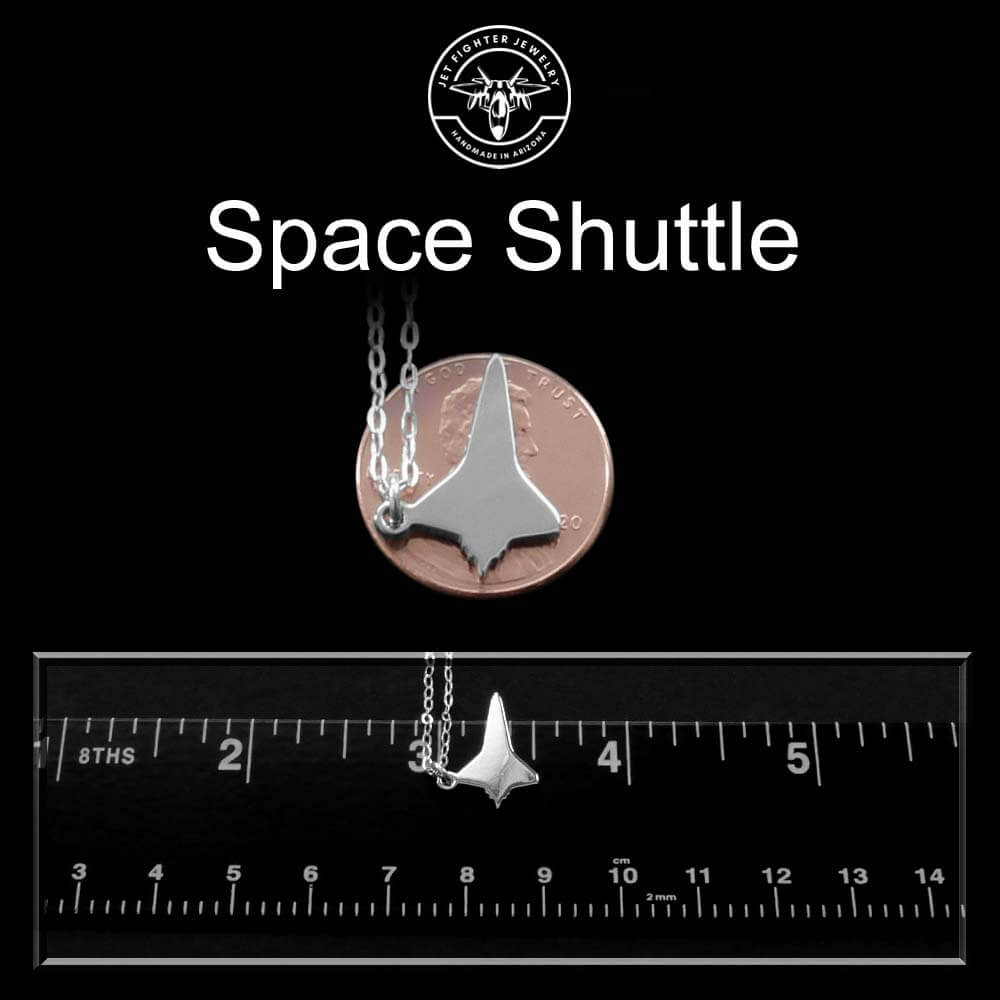 Sterling silver space shuttle necklace pendant made by jet fighter jewelry on a black background with a ruler for scale.