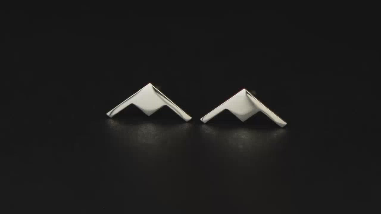 Pair of B-21 Raider Bomber Jet Fighter sterling silver stud earrings on a turntable with a dark background